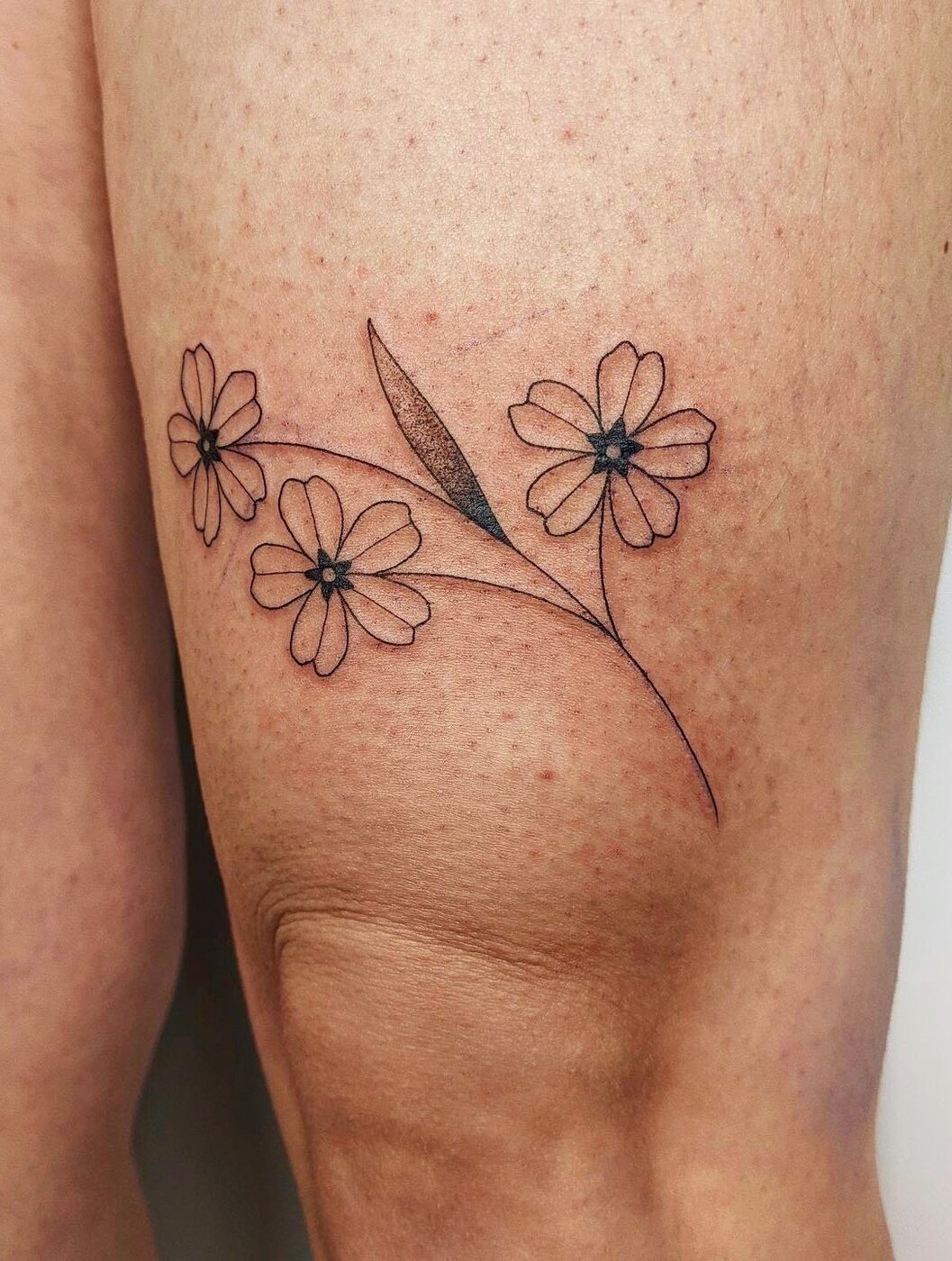 Tatouage fine line d'un bouquet délicat
